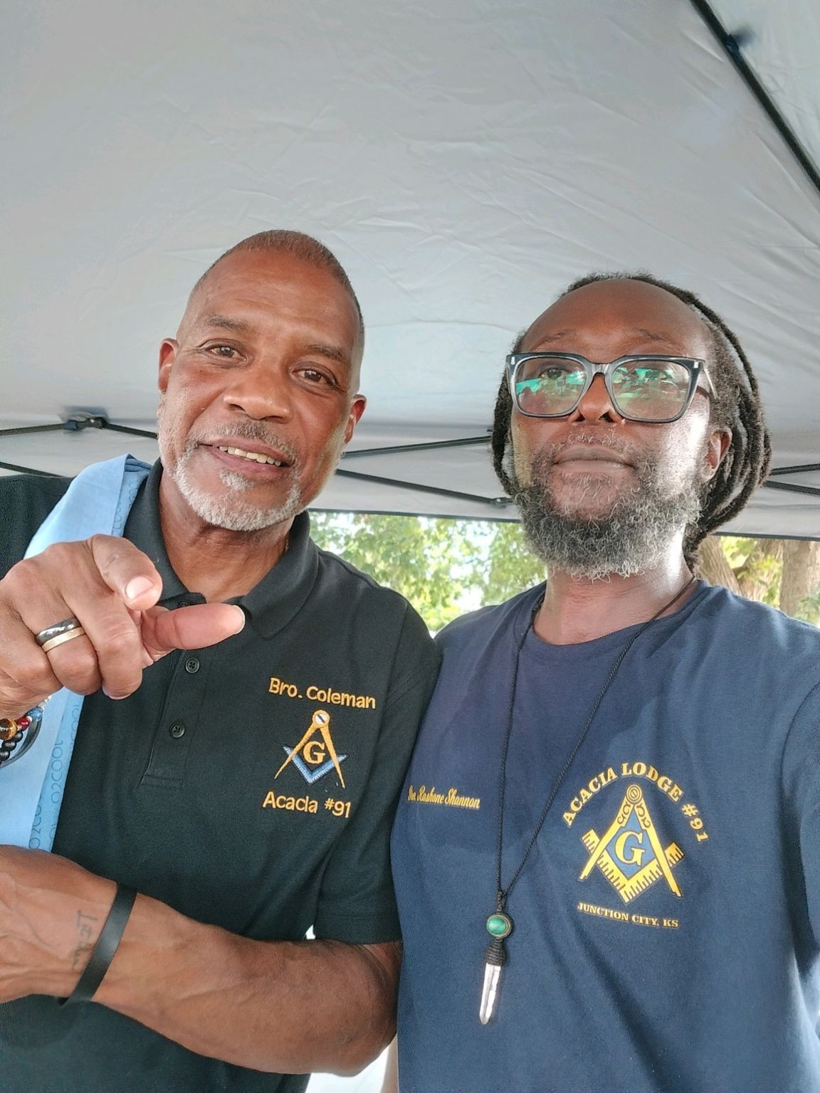 Two Acacia Lodge brothers share a moment beneath a canopy