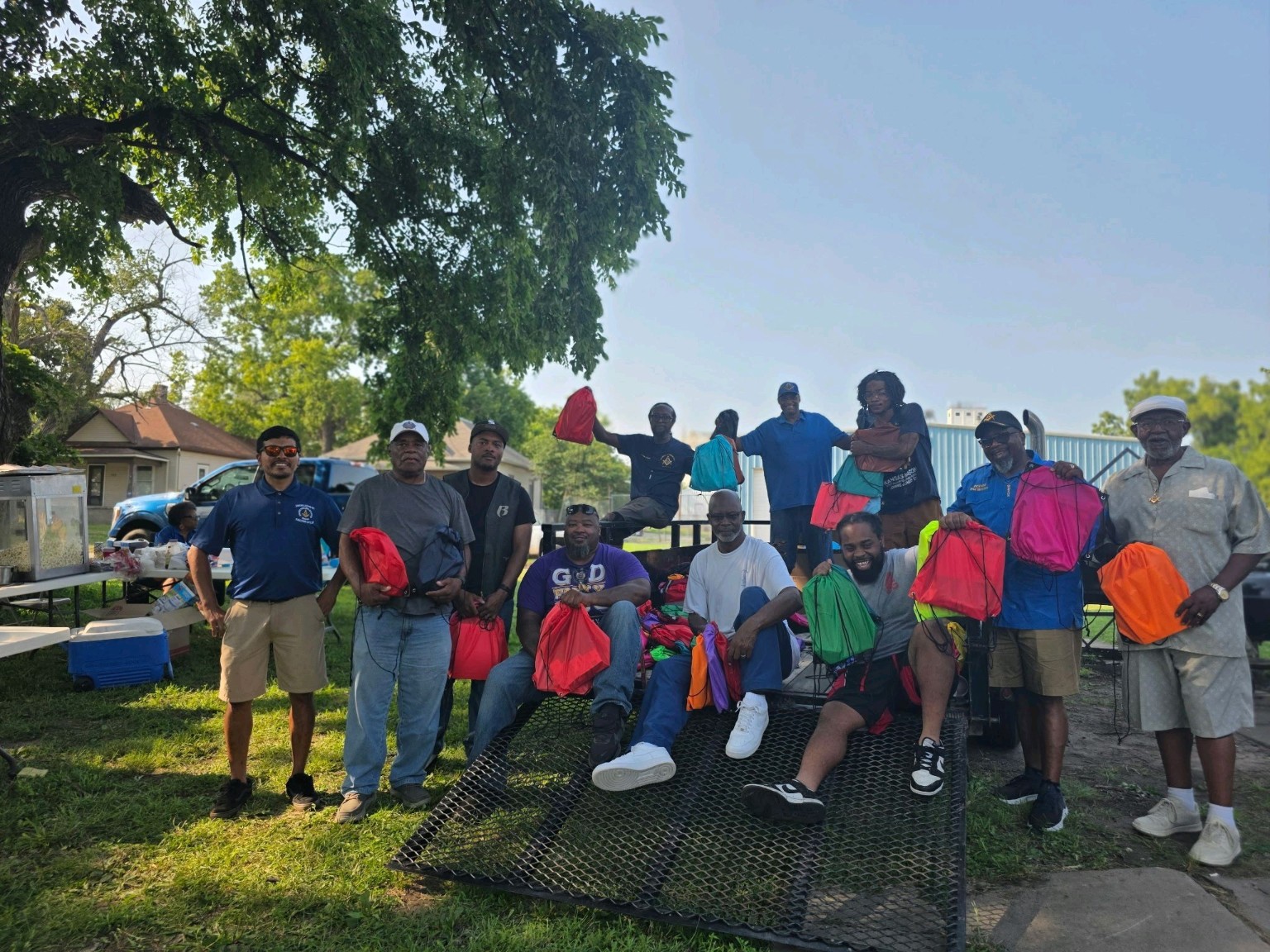 Acacia Lodge brothers and community partners gather with the bookbags prepared for local students