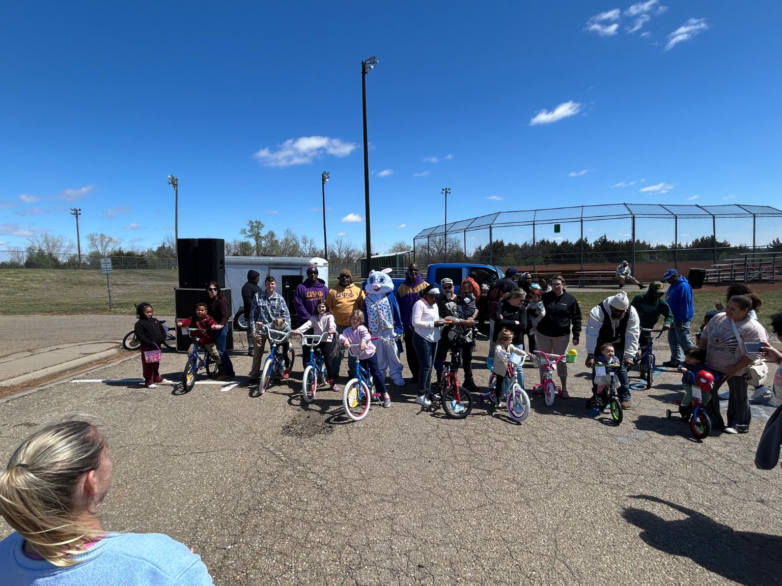 Children, families, Acacia Lodge brothers, and the Easter Bunny gather with giveaway bicycles at North Park